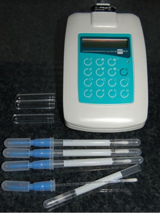 A swab testing machine, with a green key pad, and white, clear and blue plastic swabs.