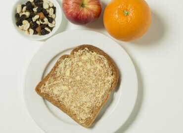 Apple, orange, raisins and slice of toast with lower fat spread