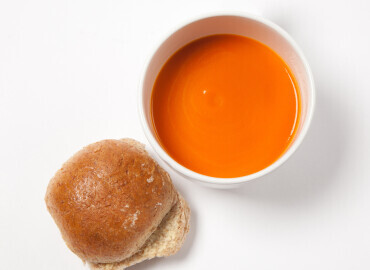 Bowl of tinned tomato soup and a bread roll with lower fat spread