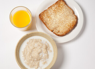 Bowl of porridge, slice of wholemeal toast and lower fat spread, and a glass of fresh orange juice 