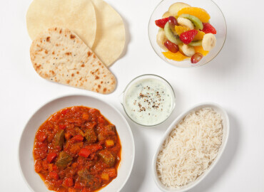 Beef curry with brown rice, raita, naan bread and poppadoms, followed by a fruit salad 