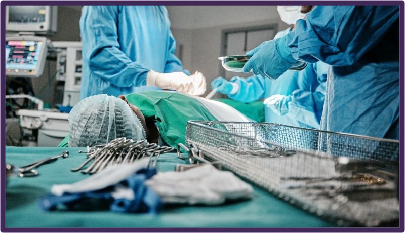 A hospital operating theatre showing two surgeons and a patient