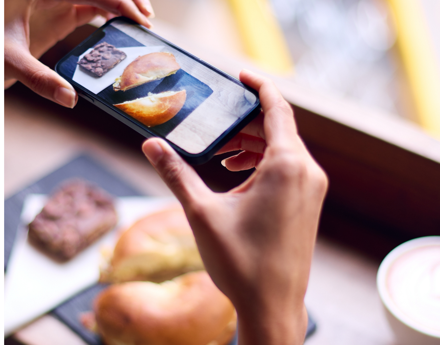 A woman taking a photo of her food using a smartphone