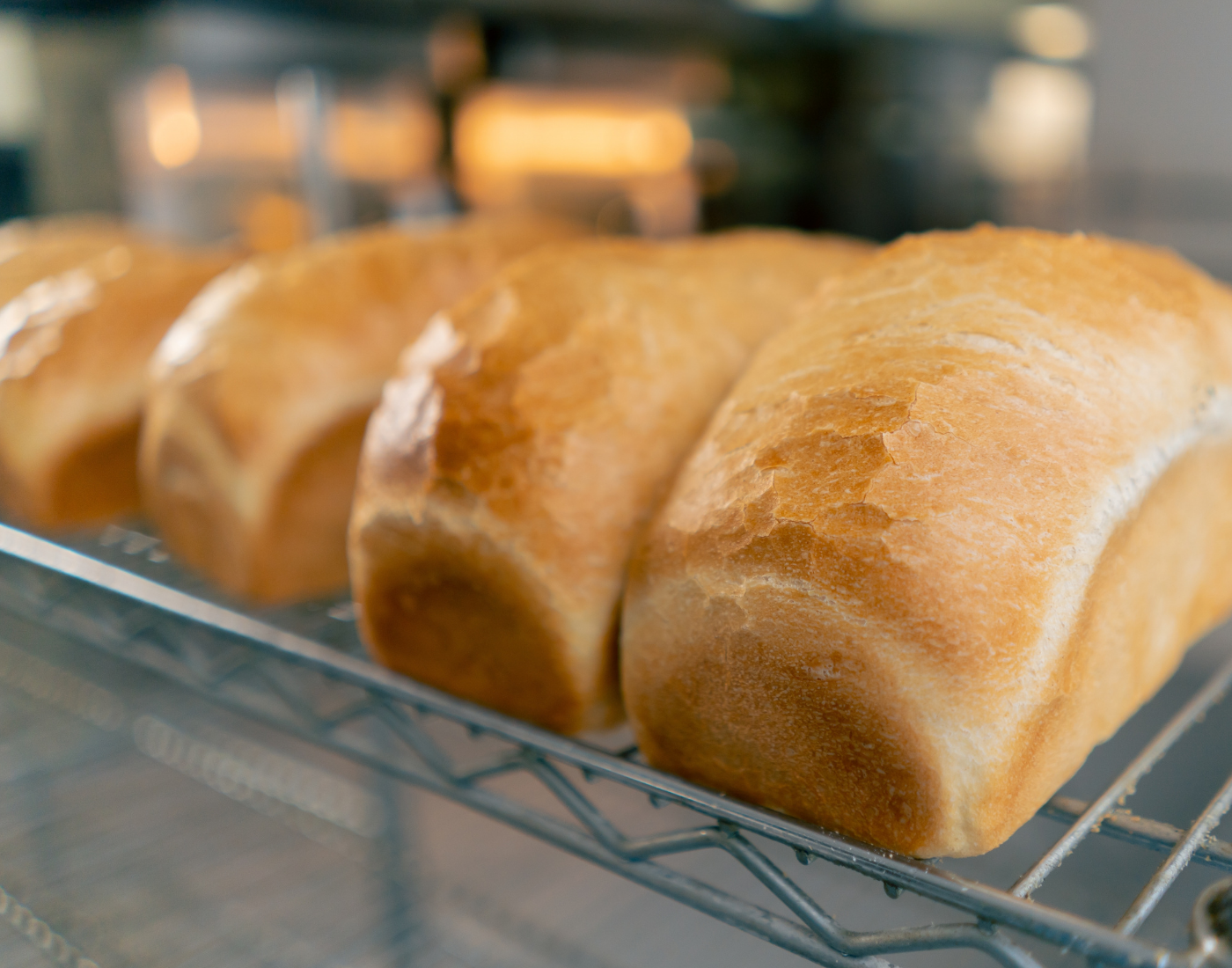 loaves of commerial bread sitting on a wire cooling rack
