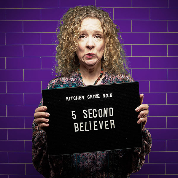 Mock mug shot photograph of a woman holding a sign saying 'kitchen crimes number 8: 5 second believer'