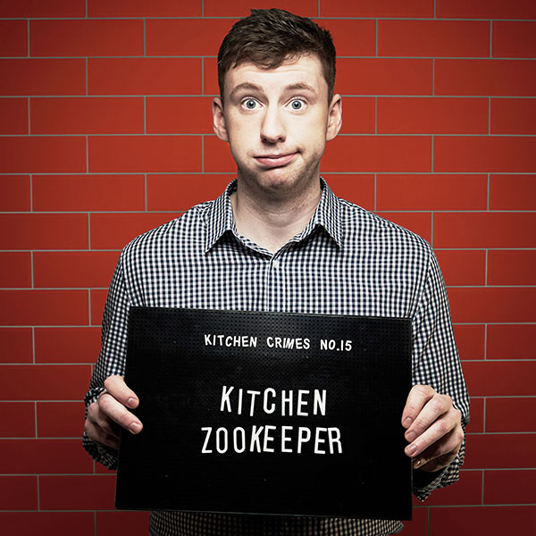 Mock mug shot photograph of a man holding a sign saying kitchen crimes number 15: kitchen zookeeper
