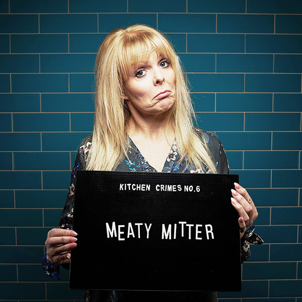 Mock mug shot photograph of a woman holding a sign saying kitchen crimes number 6: meaty mitter